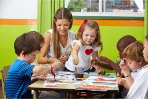 a group of toddlers painting inside a childcare facility